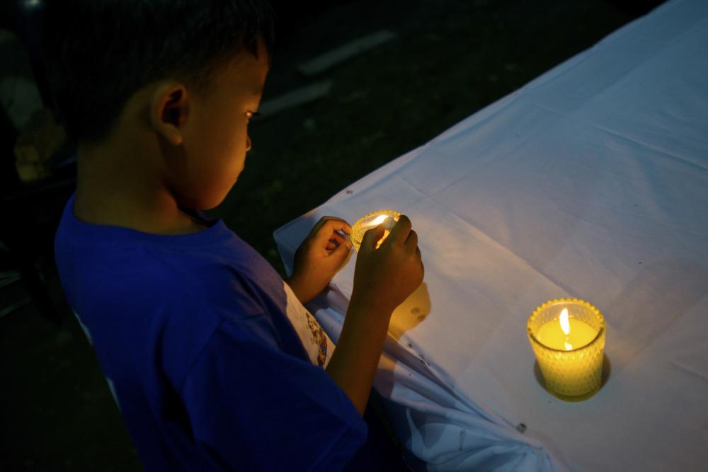 Boy lights a candle