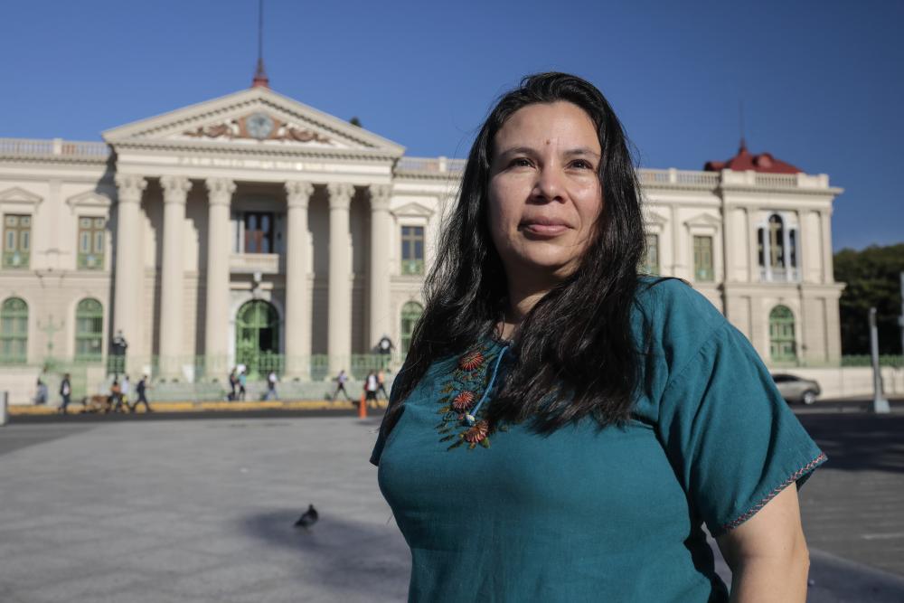 A woman stands outside in front of a building