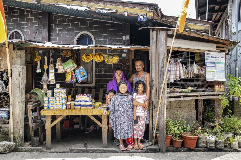 Image of family from Philippines poses for camera in their shop