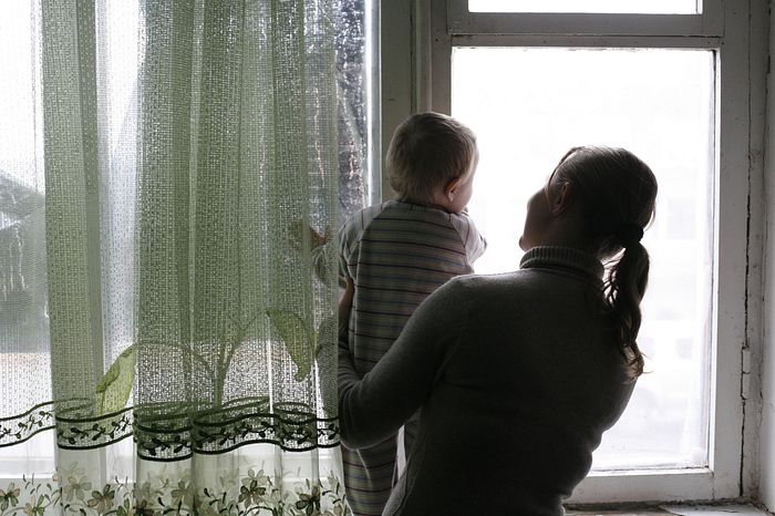 A woman and a boy looking through a window in Chermalyk