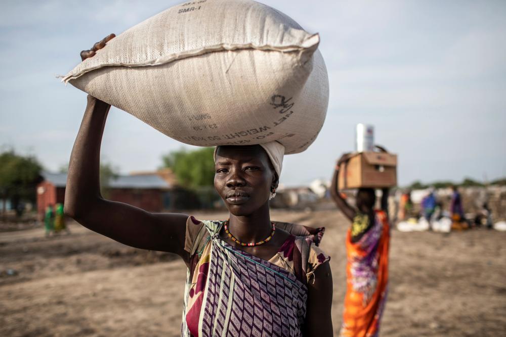 Woman carries food from a distribution
