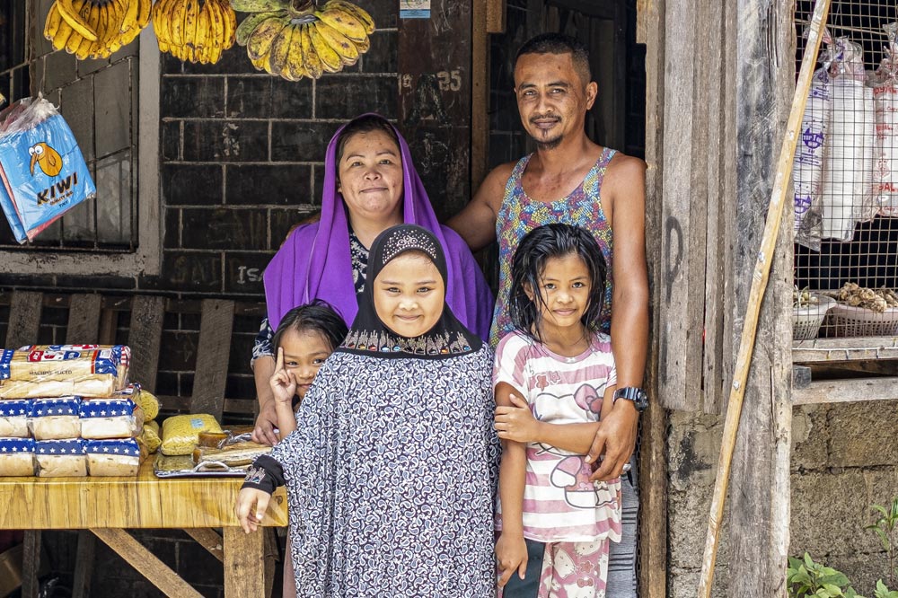 Image of family from Philippines poses for camera in their shop