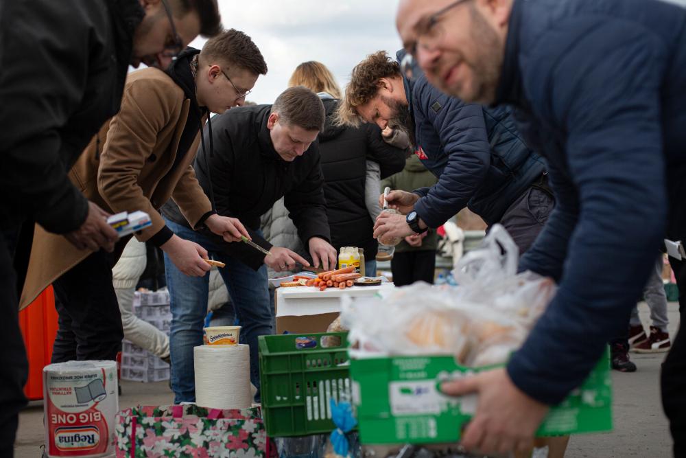 Voluntarios en un cruce fronterizo en Polonia preparan comida para las personas que han huido de Ucrania buscando seguiridad y refugio. 