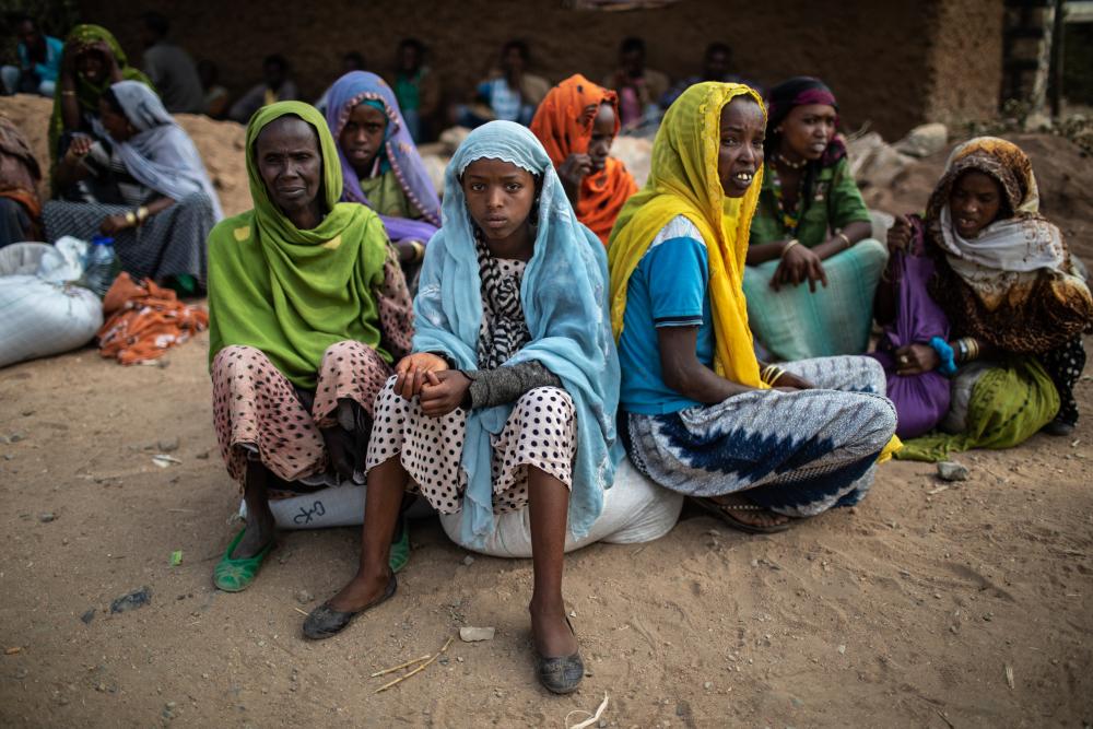 Group of women sit in circle on ground