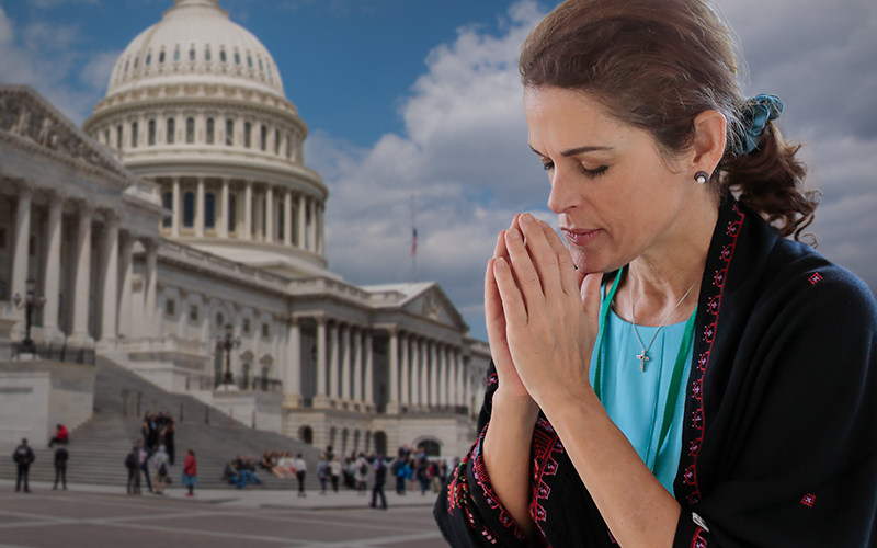 Woman in front of the Capitol building praying