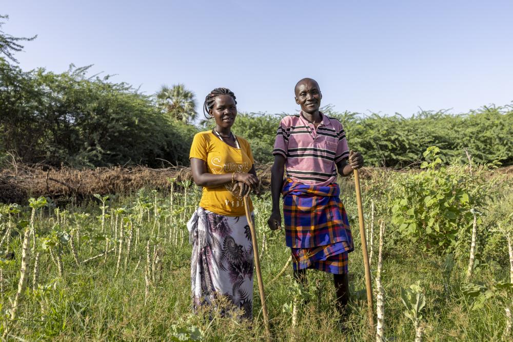 Woman and man stand in a field of crops in Kenya