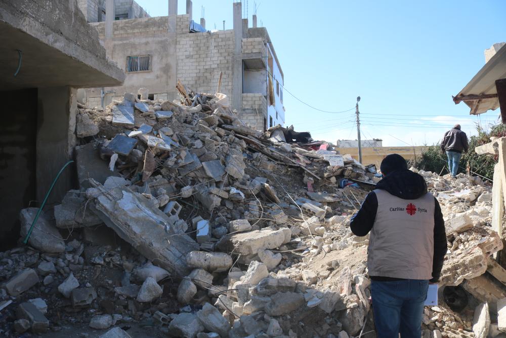 Relief worker in front of rubble in Syria