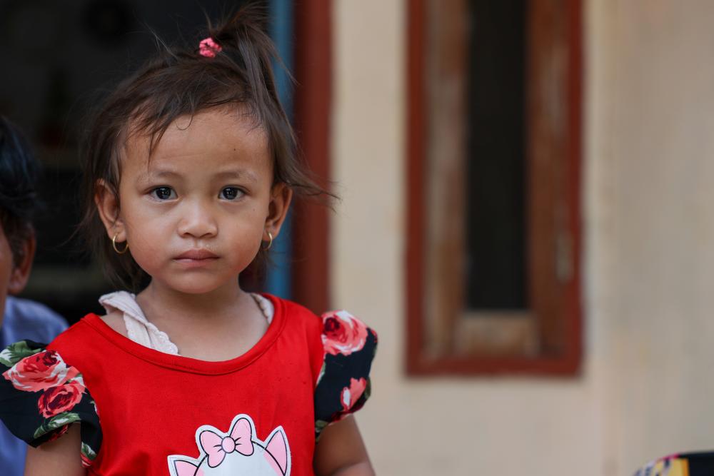 child in front of house