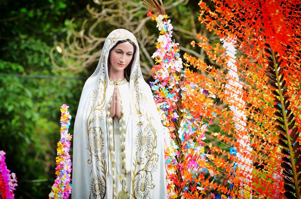 Nuestra Señora de Fátima rodeada de adornos florales de diferentes colores