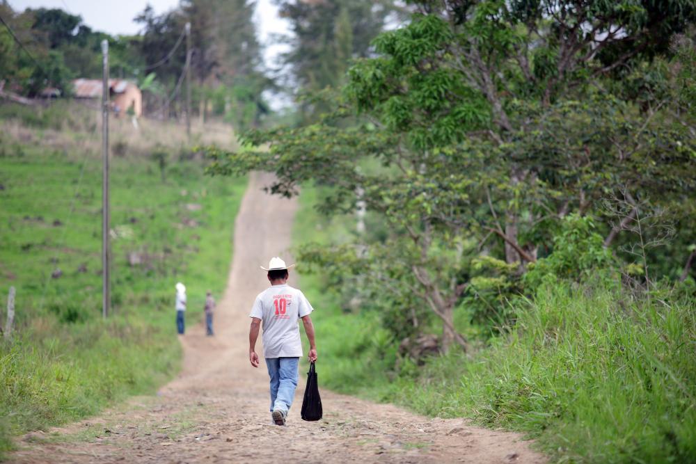 Man from Guatemala is walking down a dirt road