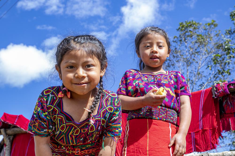 Dos niñas de Guatemala celebran una comunidad restaurada