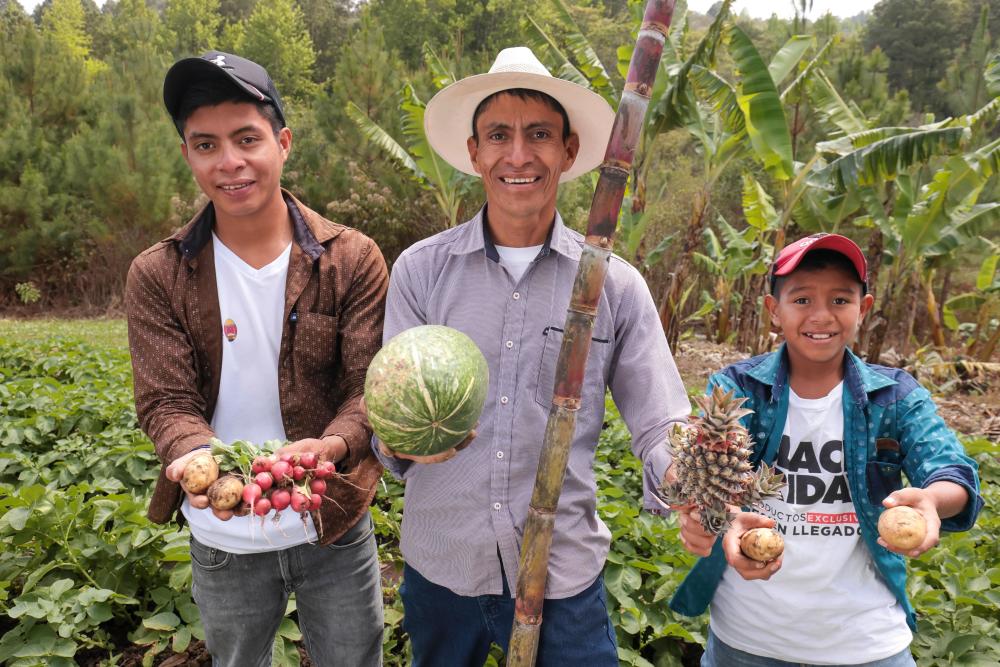Nery y sus hijos muestran algunos de los productos que cosecharon esta temporada