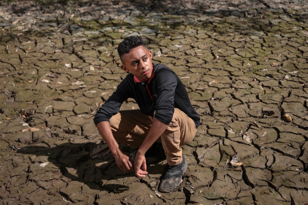 Joven contempla la tierra árida producto del cambio climático 