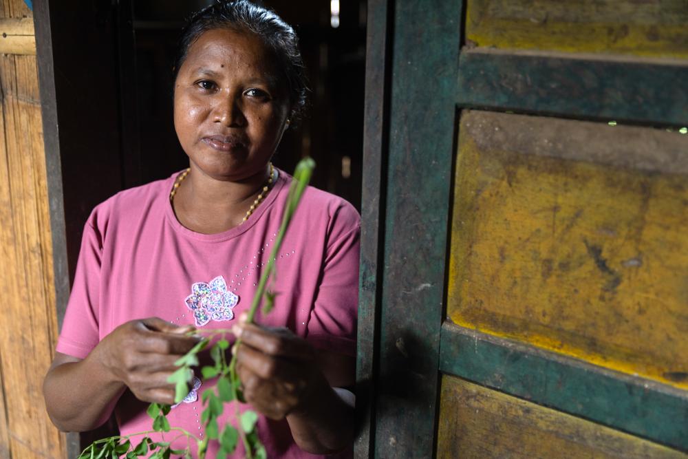 Woman in doorway holding plant