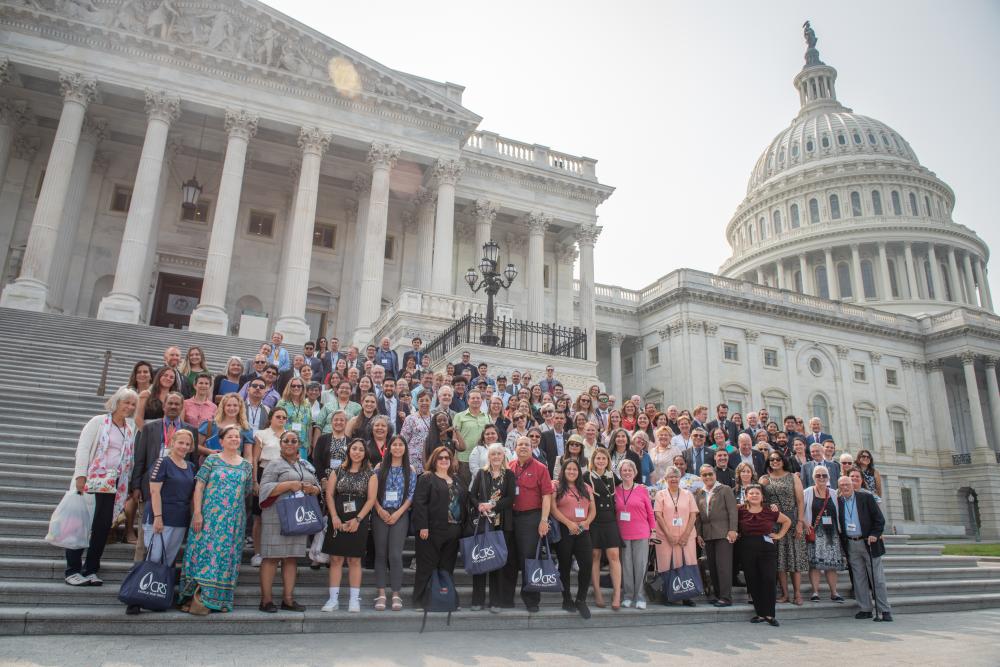 A group of advocates stand in front of the United States Capitol building