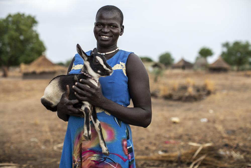 Woman from South Sudan holding a goat
