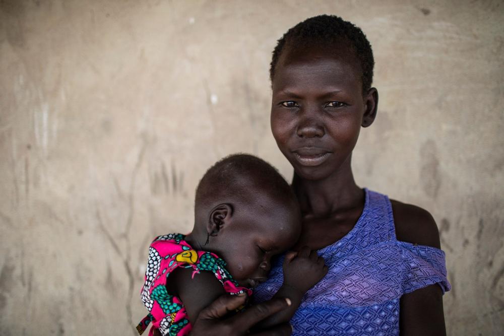 A woman holding her baby on her chest