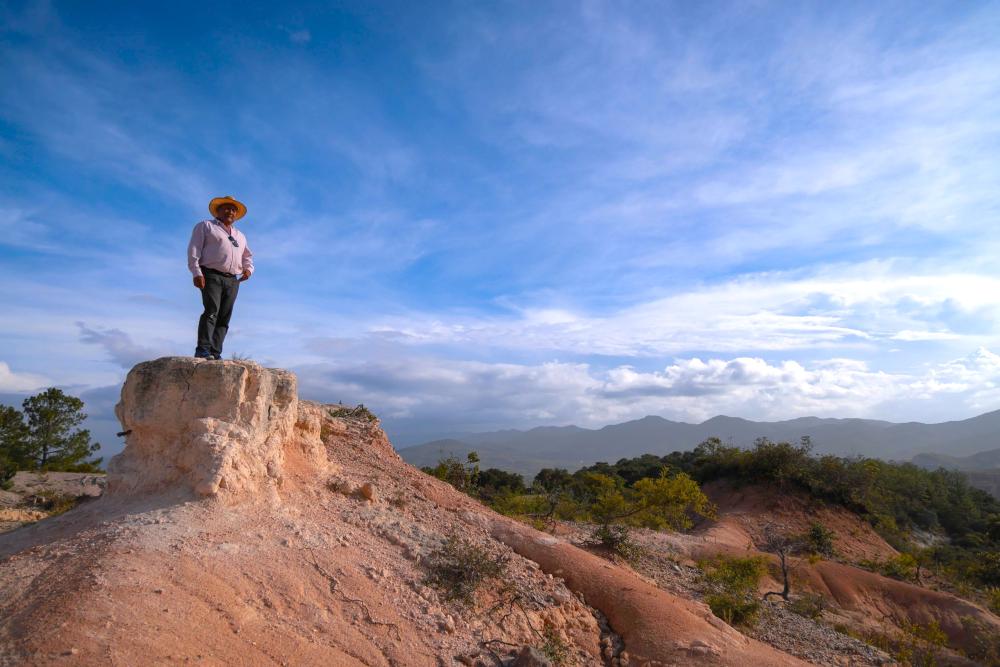 Man standing on a rock at the top of a mountain