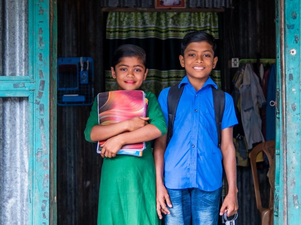 Dos niños saliendo de su casa rumbo a la escuela