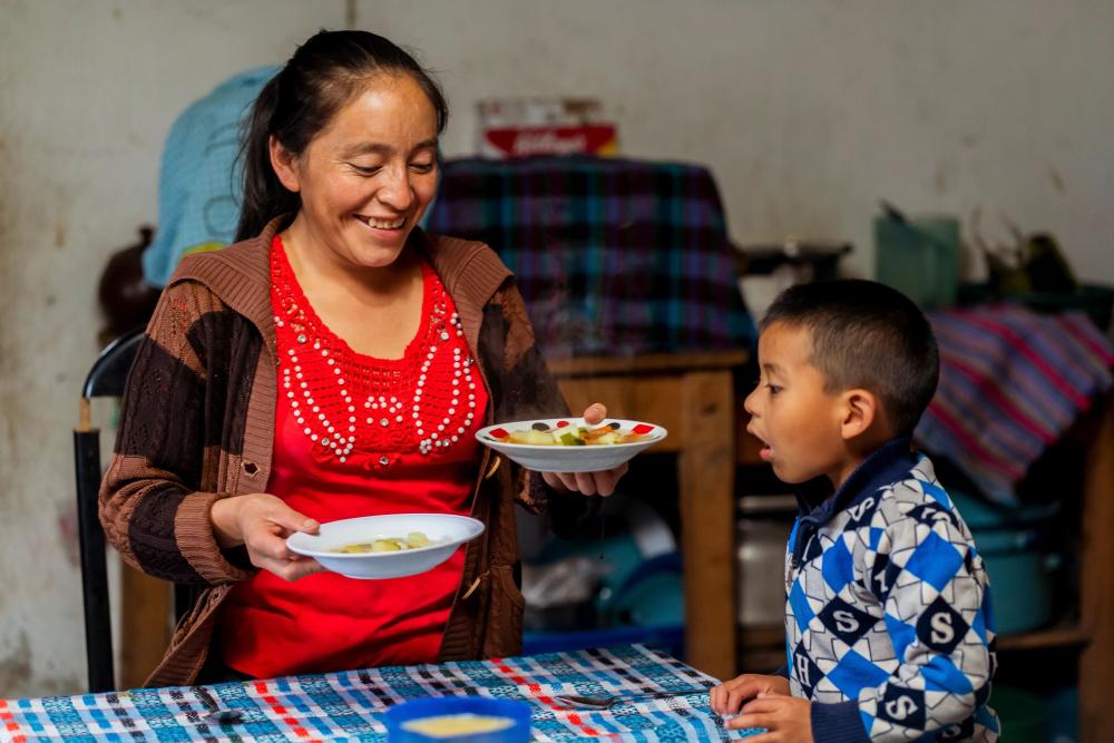 Mujer y su hijo a la mesa a punto de comer