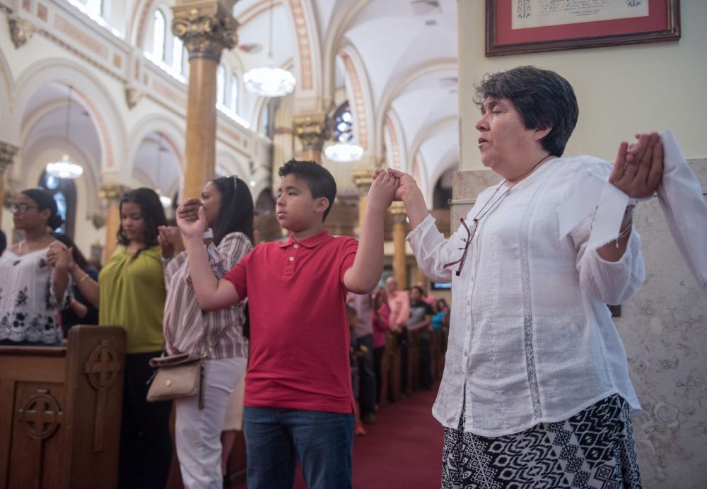 Group of people holding hands in prayer